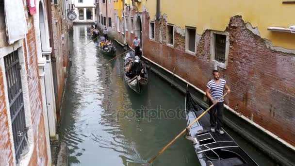 A turisták gondolák úszni végig egy keskeny csatorna Street, Velence — Stock videók