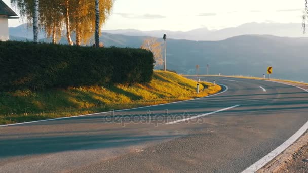 Moto-Biker fährt auf einer Bergstraße ab der Kurve. Landschaft mit Blick auf die Alpen, Österreich — Stockvideo