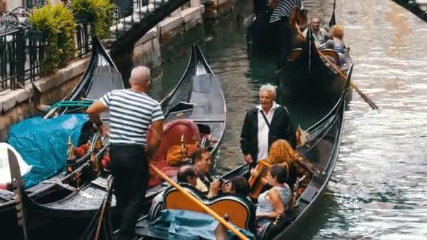 Gondoler med turister simma längs en smal kanal i Venedig Street, Italien — Stockvideo