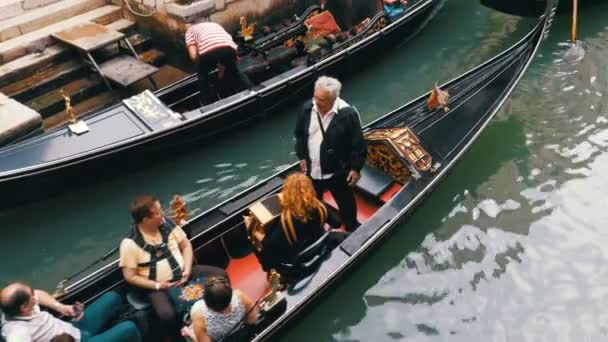 A turisták gondolák úszni végig egy keskeny csatorna Street, Velence — Stock videók