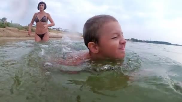 Mom は、川で泳ぐ子供を教えています。 — ストック動画