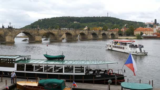 Paisaje vista del puente de Praga y el barco de autobús acuático flotando en el río Vitava — Vídeo de stock