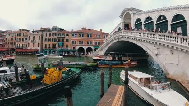 Rialto-hídtól, Velence, Olaszország. Tömeg, az emberek a hídon és a hajók haladnak mentén a víz — Stock videók