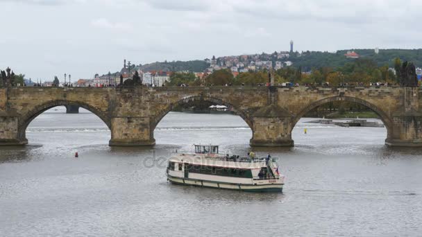 Paisaje vista del puente de Praga y el barco del autobús acuático flotando en el río Moldava — Vídeo de stock