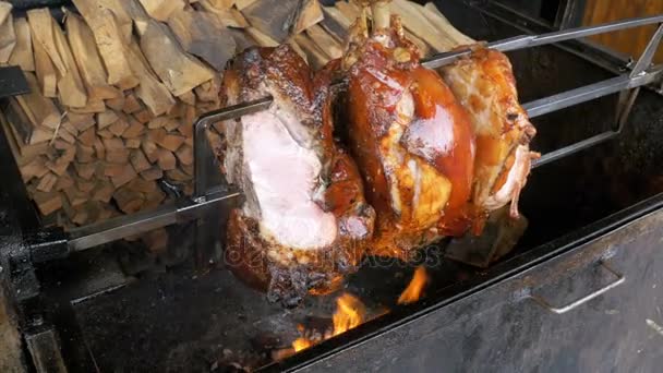 Carne grossa Coscia di maiale arrosto preparata su uno spiedo sopra un fuoco aperto. Street food a Praga, Repubblica Ceca . — Video Stock