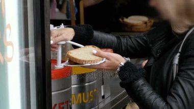 Bir sokak Cafe kadında ketçap bir Hot Dog'smear. Prague, Çek Cumhuriyeti