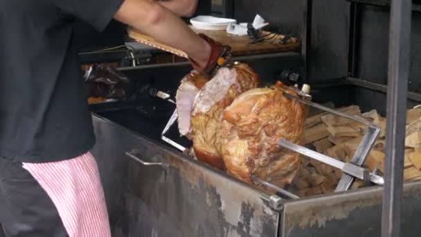 Pieza grande de carne de cerdo asado pierna preparada en una saliva por encima de un fuego abierto. Comida para llevar en Praga, República Checa . — Vídeo de stock