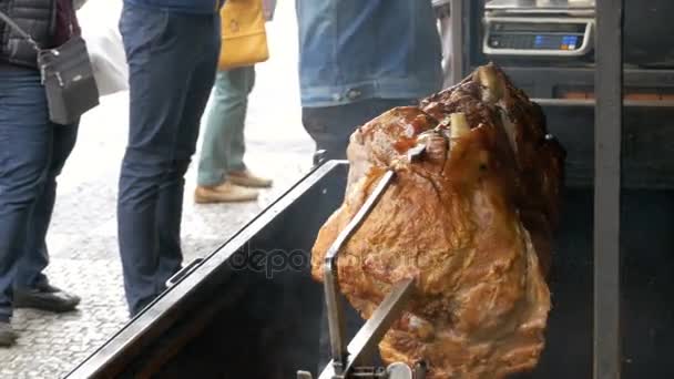 Pieza grande de carne de cerdo asado pierna preparada en una parrilla por encima de un fuego abierto. Comida para llevar en Praga, República Checa . — Vídeos de Stock