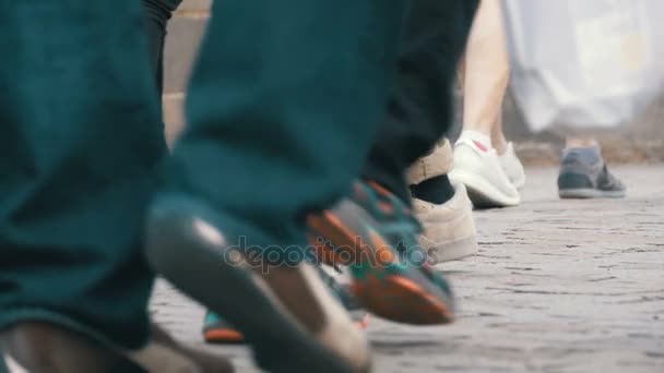 Füße von Menschen, die in Zeitlupe auf der Straße laufen — Stockvideo