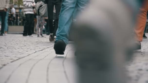 Ноги толпы людей, идущих по улице в медленном движении — стоковое видео