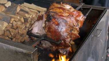 Büyük parça et Kızartma domuz eti şiş üzerinde bir açık ateş üzerinde hazırlanan bacak. Sokak gıda Prag, Çek Cumhuriyeti.