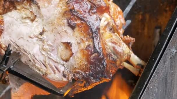 Large Piece meat Roast Pork Leg prepared on a grill above an Open Fire. Street food in Prague, Czech Republic. — Stock Video