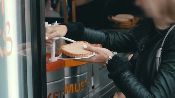 Femme dans un café de rue frotte Ketchup sur un hot-dog. Prague, République tchèque — Video