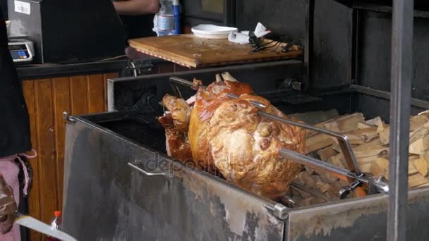 Pieza grande de carne de cerdo asado pierna preparada en una parrilla por encima de un fuego abierto. Comida para llevar en Praga, República Checa . — Vídeo de stock