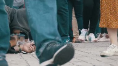 Sadaka üzerinden geçen insanlar için kaldırımda şapkalı evsiz dilenci adam yalvarır