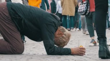 Dilenci evsizi sadaka insanlar geçen tarafından kaldırım yalvarır üzerinde onun elinde plastik kap ile