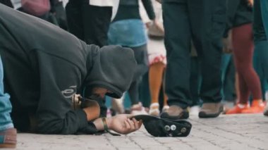 Sadaka üzerinden geçen insanlar için kaldırımda şapkalı evsiz dilenci adam yalvarır
