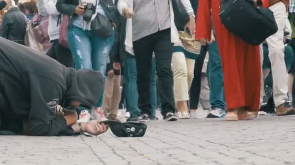 Dakloze bedelaar Man met een hoed op de stoep smeekt om Alms van passerende mensen — Stockvideo