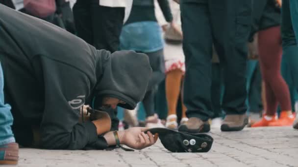 Obdachloser Bettler mit Hut auf dem Bürgersteig bettelt um Almosen von Passanten — Stockvideo