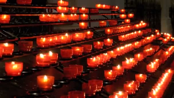 Много свечей зажигается в христианской церкви — стоковое видео