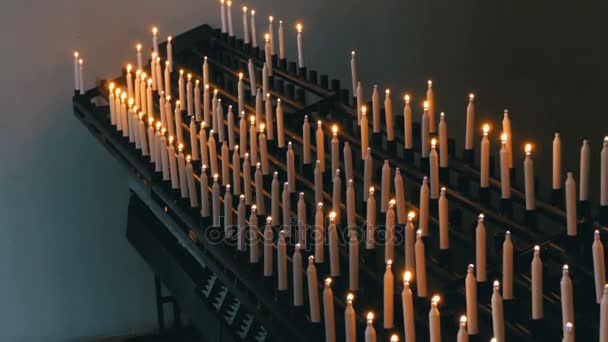 Много свечей зажигается в христианской церкви — стоковое видео