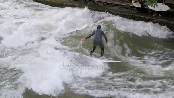 Városi szörfösök lovagolni az állóhullám Eisbach folyó, München, Németország. Lassú mozgás — Stock videók