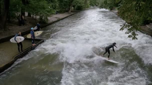 Urbana surfare på en konstgjorda våg på Eisbach river i centrala München. Slow Motion — Stockvideo