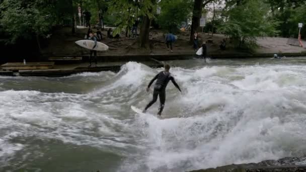 Urbana surfare på en konstgjorda våg på Eisbach river i centrala München. Slow Motion — Stockvideo