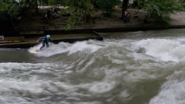 Surfistas urbanos montam a onda estacionária no rio Eisbach, Munique, Alemanha — Vídeo de Stock