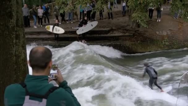 Városi hullámlovas egy mesterséges hullám a Eisbach folyó, központjában München, Németország — Stock videók