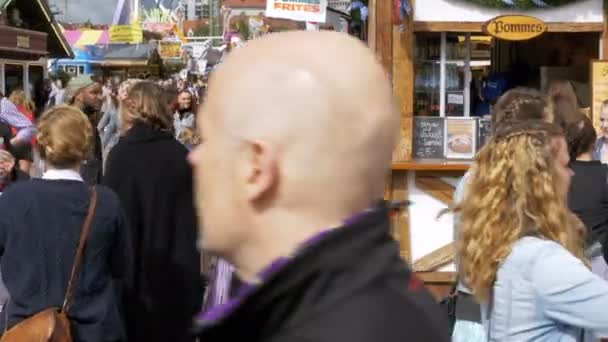 Mensen lopen langs de centrale straat van het Oktoberfest festival. Beieren, Duitsland — Stockvideo