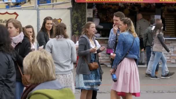 Gente con trajes nacionales bávaros caminando por la calle del festival Oktoberfest. Munich, Alemania — Vídeo de stock