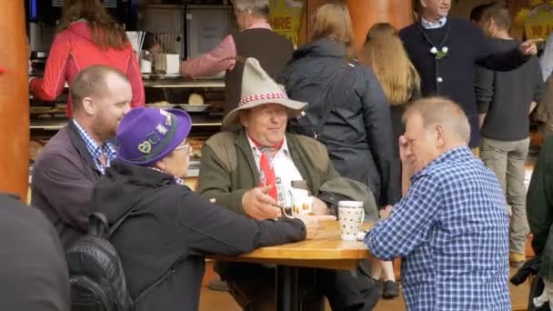 Mensen zitten aan tafel in een café op de centrale straat van het Oktoberfest festival. Beieren, Duitsland — Stockvideo