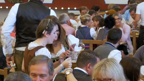 Meninas em trajes nacionais dentro de uma grande barraca de cerveja celebram Oktoberfest. Baviera, Alemanha . — Vídeo de Stock