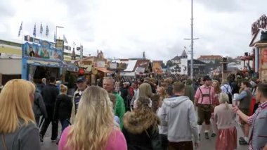 İnsanlar ulusal Bavyera giysili Oktoberfest festival alanı cadde boyunca yürüyüş. Münih, Almanya