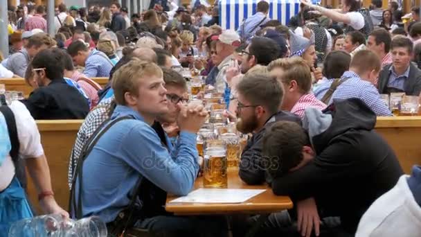 Részeg ember az asztalnál Oktoberfest ünnepelni egy nagy söröző az utcán. Bavaria, Németország — Stock videók