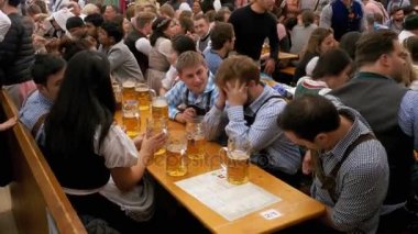 Masadaki sarhoş insanların bir büyük bira çadırına Oktoberfest kutlamak. Bavyera, Almanya