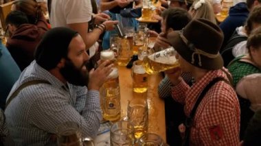 Masadaki sarhoş insanların bir büyük bira çadırına Oktoberfest kutlamak. Bavyera, Almanya