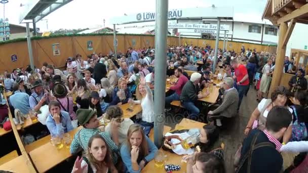 Opilých lidí u stolu oslavit Oktoberfest v velké pivní bar na ulici. Bavorsko, Německo — Stock video