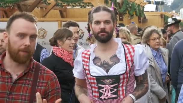 Homem bêbado em uma rua vestido com um dirndl feminino está se divertindo no Oktoberfest. Baviera. Movimento lento — Vídeo de Stock