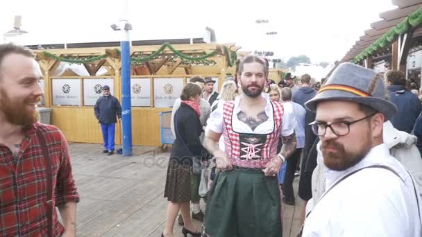 Dronken man in een straat die is gekleed in een vrouwelijke dirndl is het hebben van pret op het Oktoberfest. Bavaria. Slow Motion — Stockvideo