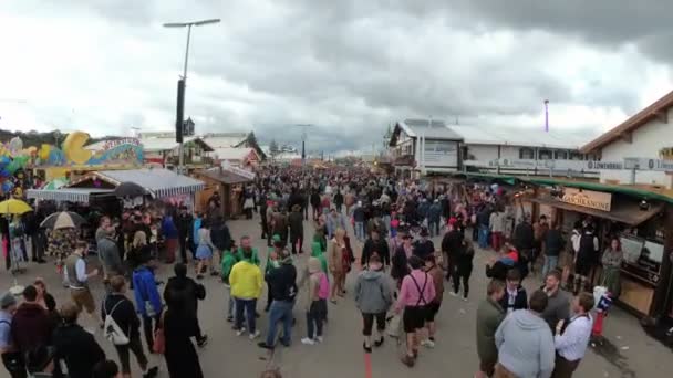 Камера движется с высоты толпы людей на центральной улице фестиваля Октоберфест. Бавария, Германия — стоковое видео