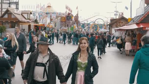 Orang-orang berjalan di sepanjang jalan pusat festival Oktoberfest. Bavaria, Jerman — Stok Video