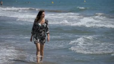Ağır çekimde sahilde deniz kıyısında kız mayo içinde çalışır