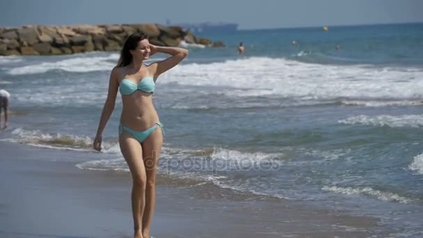 Ağır çekimde sahilde deniz kıyısında kız mayo içinde çalışır — Stok video