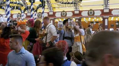 Ulusal kostümleri sarhoş kişilik bir kalabalık bira içmek ve eğlenmek içinde bir büyük bira salonu. Bavyera, Almanya