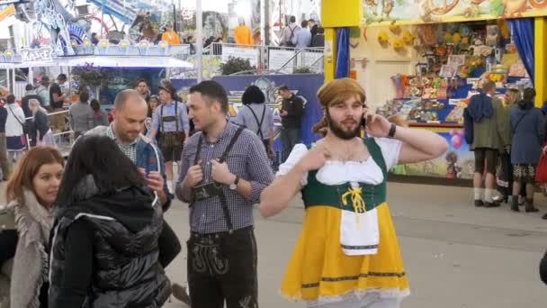 Un borracho en una calle vestido con un dirndl femenino se está divirtiendo en el Oktoberfest. Baviera. Moción lenta — Vídeos de Stock