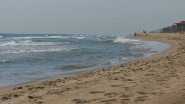 Τα κύματα της θάλασσας είναι το τροχαίο σε μια παραλία με άμμο — Αρχείο Βίντεο
