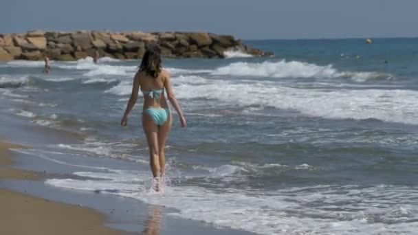 Menina em maiô corre ao longo da costa do mar na praia em Slow Motion — Vídeo de Stock