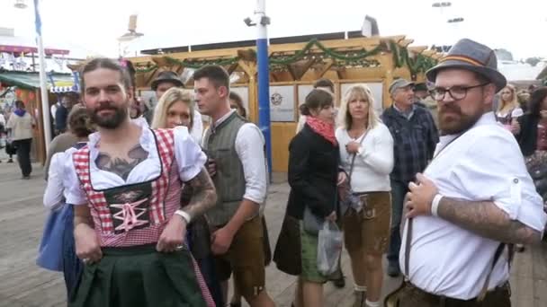 Pijany mężczyzna przy ulicy ubrana w dirndl kobieta się bawią się na Oktoberfest. Bawarii. Zwolnionym tempie — Wideo stockowe